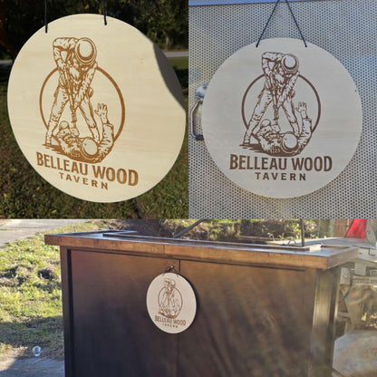 Wooden sign with 'Belleau Wood Tavern' logo on a stand outdoors.
