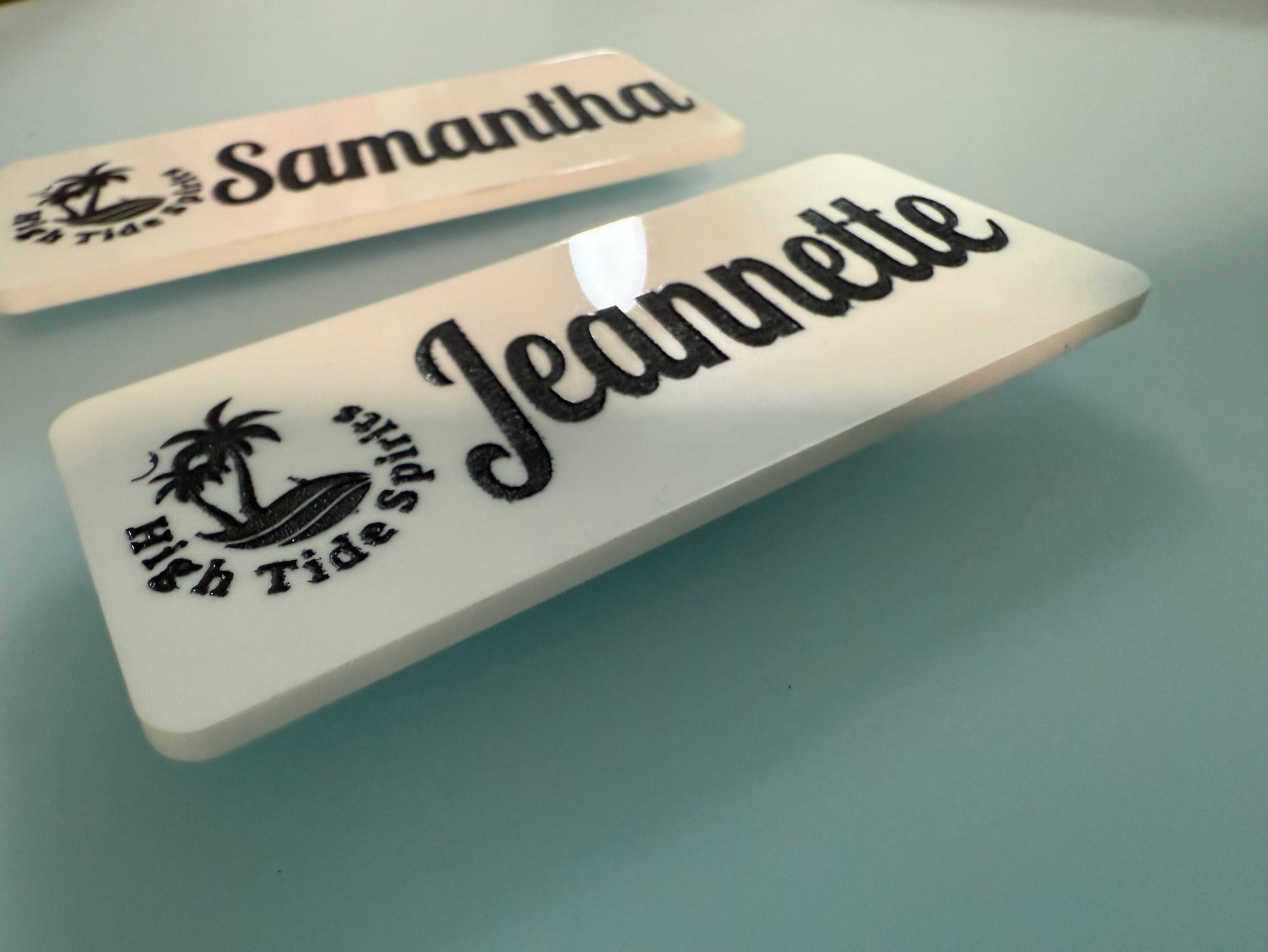 Two nameplates with 'Samantha' and 'Jeannette' engraved on a reflective surface.